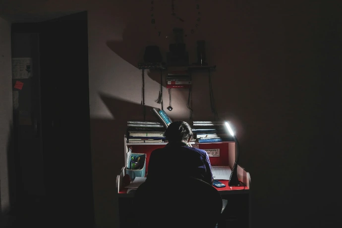 man in black shirt sitting on chair using computer